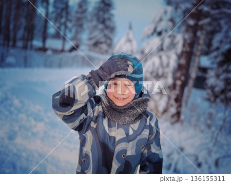 funny portrait of little boy in winter overall in snowy countryside funny portrait of little boy in winter overall in snowy countryside 136155311