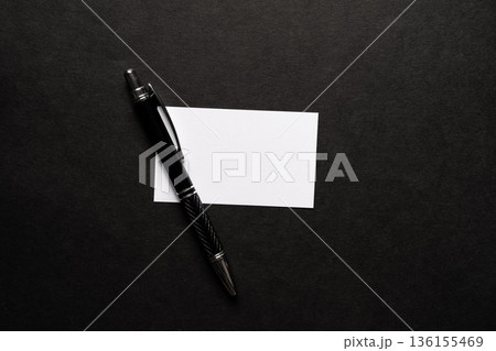 黒背景に置いてあるボールペンとメモ 136155469