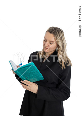 Woman in Black Jacket Reads Notes in a Teal Glitter Notebook 136156031