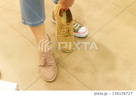 Unrecognizable woman trying on shoes 136156727
