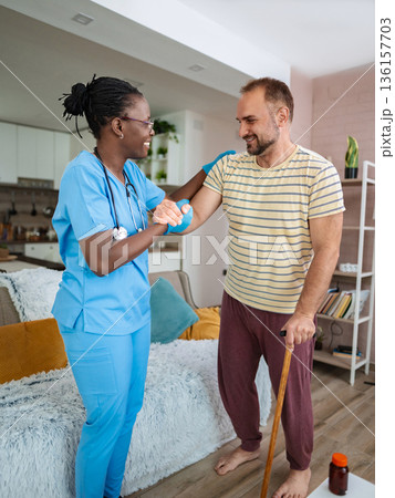 Caregiver aids patient in uplifting therapy session Caregiver aids patient in uplifting therapy session 136157703