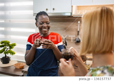 Enjoying warm coffee and friendship in a cozy kitchen space 136157737