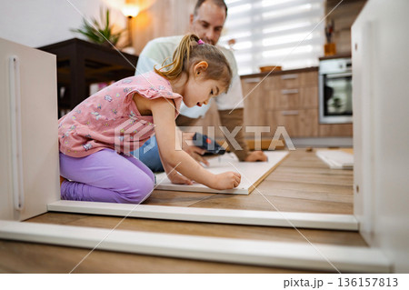 Father and daughter working together to build furniture at home Father and daughter working together to build furniture at home 136157813