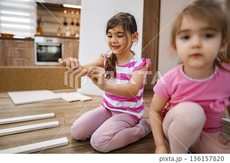 Sisters create a masterpiece at home during a sunny afternoon 136157820