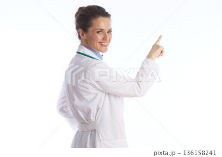 Friendly Doctor Looking Back and Pointing to Health Information Friendly Doctor Looking Back and Pointing to Health Information 136158241