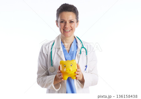 Female Healthcare Professional with Piggy Bank Female Healthcare Professional with Piggy Bank 136158438