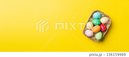 Multi colors Easter eggs in the woven basket on colored background . Pastel color Easter eggs. holiday concept with copy space 136159989