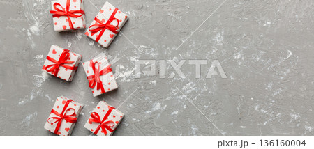 Valentine day composition: red gift box with bow and heart. Christmas present. View from above. Space for text. Holday greeting card Valentine day composition: red gift box with bow and heart. Christmas present. View from above. Space for text. Holday greeting card 136160004