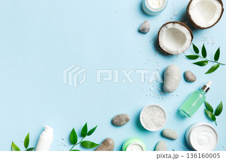 Coconut with jars of coconut oil and cosmetic cream on colored background. Top view. Free space for your text. Natural spa coconut cosmetics and organic treatment concept Coconut Spa composition Coconut with jars of coconut oil and cosmetic cream on colored background. Top view. Free space for your text. Natural spa coconut cosmetics and organic treatment concept Coconut Spa composition 136160005