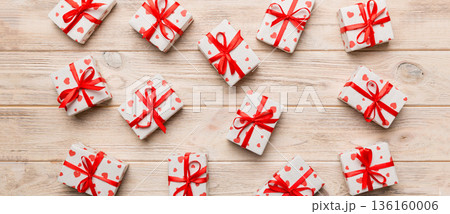 Valentine day composition Background: red gift box with bow and heart. Christmas present. View from above. Holday greeting card Valentine day composition Background: red gift box with bow and heart. Christmas present. View from above. Holday greeting card 136160006