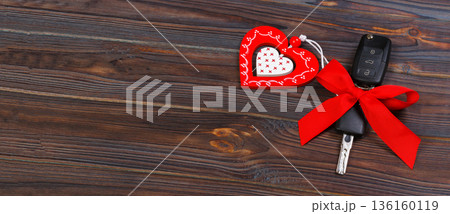 Car key with red heart on black natural background. Christmas or Valentine's Day gift or present abstract concept 136160119