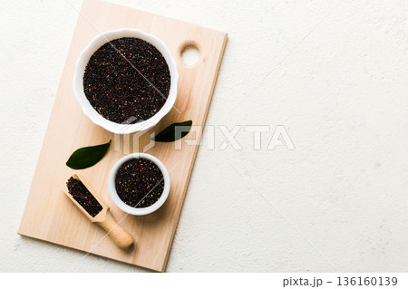 quinoa seeds in bowl and spoon on colored background. Healthy kinwa in small bowl. Healthy superfood quinoa seeds in bowl and spoon on colored background. Healthy kinwa in small bowl. Healthy superfood 136160139