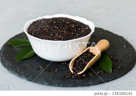 quinoa seeds in bowl and spoon on colored background. Healthy kinwa in small bowl. Healthy superfood quinoa seeds in bowl and spoon on colored background. Healthy kinwa in small bowl. Healthy superfood 136160142