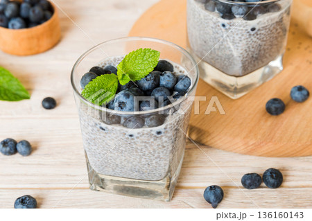 Healthy breakfast or morning with chia seeds vanilla pudding and blueberry berries on table background, vegetarian food, diet and health concept. Chia pudding with coconut milk and blueberry 136160143