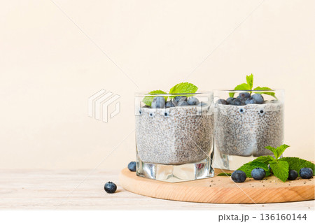 Healthy breakfast or morning with chia seeds vanilla pudding and blueberry berries on table background, vegetarian food, diet and health concept. Chia pudding with coconut milk and blueberry Healthy breakfast or morning with chia seeds vanilla pudding and blueberry berries on table background, vegetarian food, diet and health concept. Chia pudding with coconut milk and blueberry 136160144