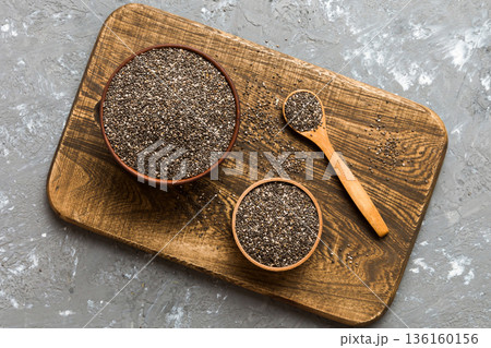 Chia seeds in bowl and spoon on colored background. Healthy Salvia hispanica in small bowl. Healthy superfood Chia seeds in bowl and spoon on colored background. Healthy Salvia hispanica in small bowl. Healthy superfood 136160156