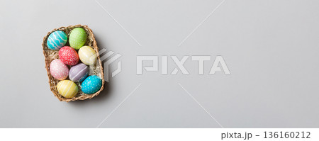 Multi colors Easter eggs in the woven basket on colored background . Pastel color Easter eggs. holiday concept with copy space 136160212