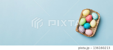 Multi colors Easter eggs in the woven basket on colored background . Pastel color Easter eggs. holiday concept with copy space Multi colors Easter eggs in the woven basket on colored background . Pastel color Easter eggs. holiday concept with copy space 136160213