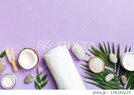 Coconut with jars of coconut oil and cosmetic cream on colored background. Top view. Free space for your text. Natural spa coconut cosmetics and organic treatment concept Coconut Spa composition 136160229