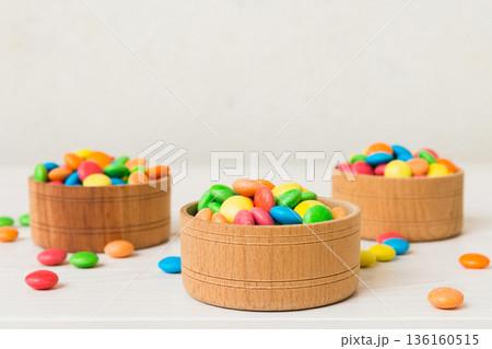 Multicolored candies in a bowl on a colored background. birthday and holiday concept. Top view with copy space Multicolored candies in a bowl on a colored background. birthday and holiday concept. Top view with copy space 136160515