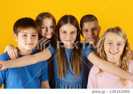 Closeup shot of happy preteen children taking selfie together on yellow background 136162060