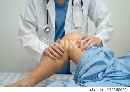 Doctor checking Asian elderly woman patient with scar knee replacement surgery in hospital. Doctor checking Asian elderly woman patient with scar knee replacement surgery in hospital. 136162083