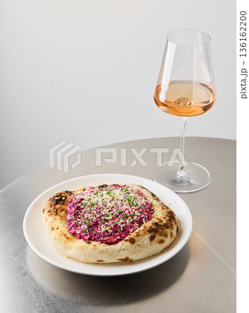 Delicious beet topped pizza paired with fine wine and floral beverage Delicious beet topped pizza paired with fine wine and floral beverage 136162200