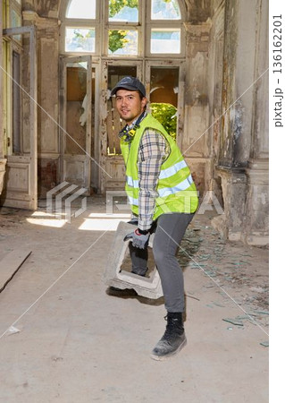 Heritage restoration contractor clearing debris with jackhammer 136162201