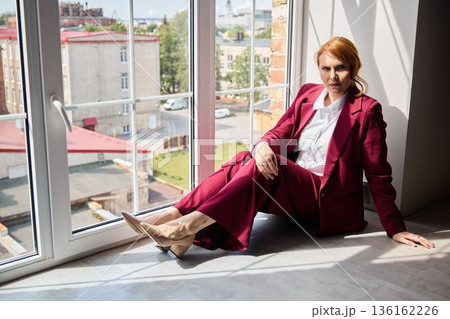 Elegant woman in deep thought observing lively city underneath sunlight 136162226