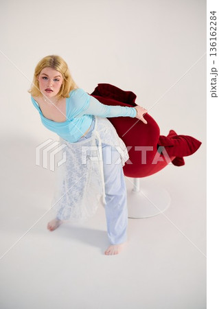 theatrical rehearsal white woman leaning forward from red chair 136162284