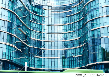Modern building with curved glass design located in a city during daytime 136162642