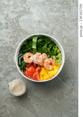 Fresh shrimp salad with greens, edamame, tomatoes, and mango served in a bowl Fresh shrimp salad with greens, edamame, tomatoes, and mango served in a bowl 136162709