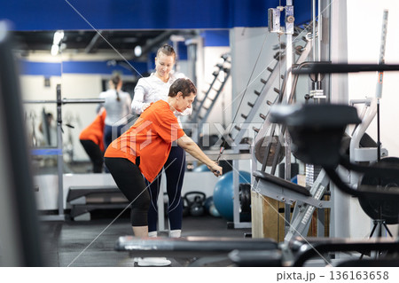 Woman receiving personal training at a gym 136163658