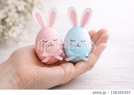 DIY Easter bunnies made from painted eggs in palm of hand. Holiday greeting card. 136164307
