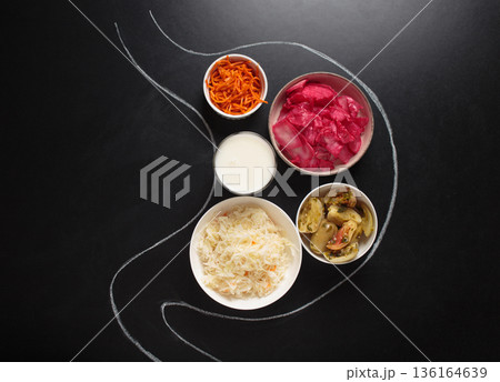 Probiotic foods for gut health inside stomach outline drawn on black chalk board top view Probiotic foods for gut health inside stomach outline drawn on black chalk board top view 136164639