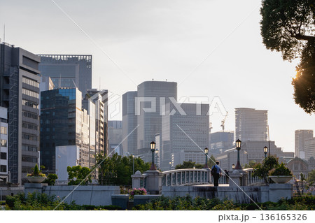 夕暮れのオフィスビル群と公園の石橋 夕暮れのオフィスビル群と公園の石橋 136165326