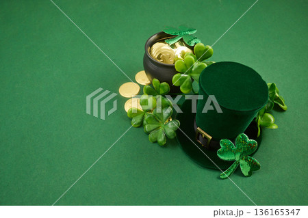 Leprechaun hat, pot of gold, shamrocks on green background Leprechaun hat, pot of gold, shamrocks on green background 136165347
