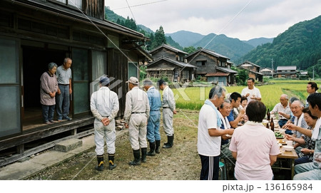 村人の宴会から排除され家先で立ち尽くす村八分の高齢夫婦 村人の宴会から排除され家先で立ち尽くす村八分の高齢夫婦 136165984