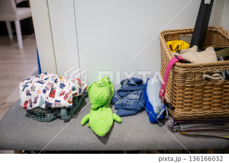Stuffed animal toy on ironing board with laundry basket, clothes and home cleaning items Stuffed animal toy on ironing board with laundry basket, clothes and home cleaning items 136166032