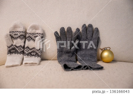 Winter gloves and mittens with christmas ornament on cozy beige background Winter gloves and mittens with christmas ornament on cozy beige background 136166043
