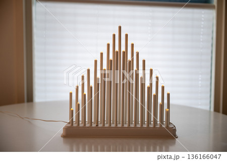 Scandinavian electric candle bridge on table with soft window light 136166047