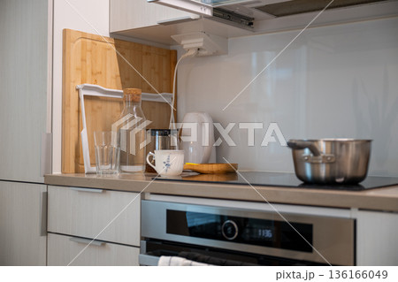 Modern kitchen countertop with kettle cups glass bottle and cooking pot Modern kitchen countertop with kettle cups glass bottle and cooking pot 136166049