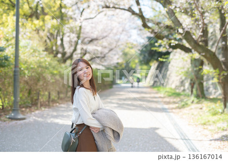 春の時期、桜の木の下で観光を楽しむ女性 春の時期、桜の木の下で観光を楽しむ女性 136167014