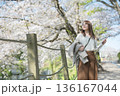 桜並木を歩く女性 136167044