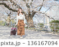 桜並木を散歩する若い女性 136167094