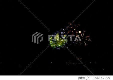 【静岡】冬の熱海海上花火大会　打ち上がる花火と砂浜で眺める人々のシルエット 136167099