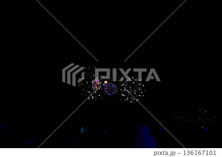 【静岡】冬の熱海海上花火大会　打ち上がる花火と砂浜で眺める人々のシルエット 136167101