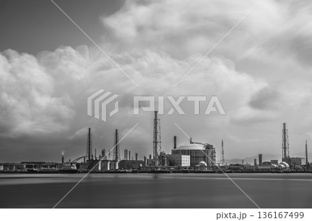 雲が流れる海沿い工業地帯のモノクロ風景 雲が流れる海沿い工業地帯のモノクロ風景 136167499