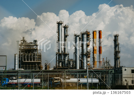 青空と雲を背景に並ぶ化学プラントの煙突群 136167503