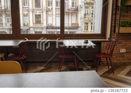A cozy restaurant interior with tables for a quick lunch, large windows overlooking the old town 136167725